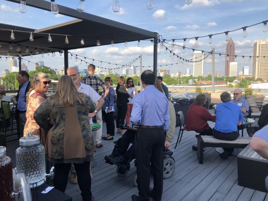 a group meeting on a rooftop with views of the atlanta skyline.