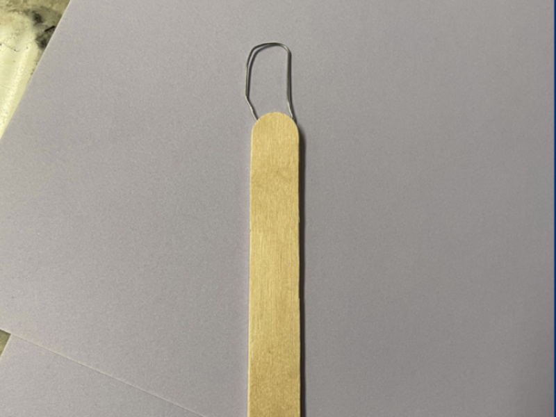 Button hook made out of popsicle sticks and a paper clip
