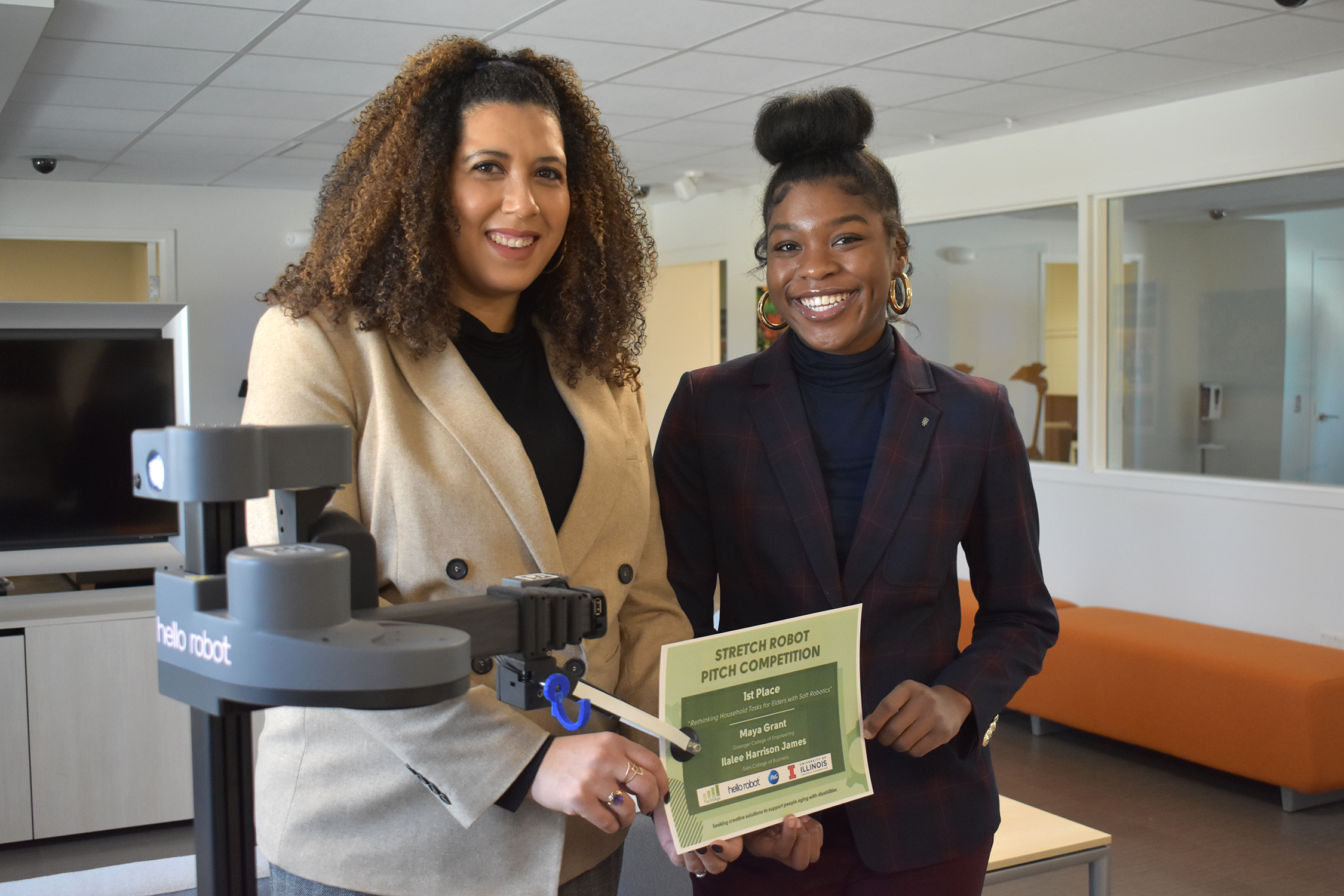 Ilalee Harrison James (left) and Maya Grant (right) post with Stretch Robot handing them an award certificate