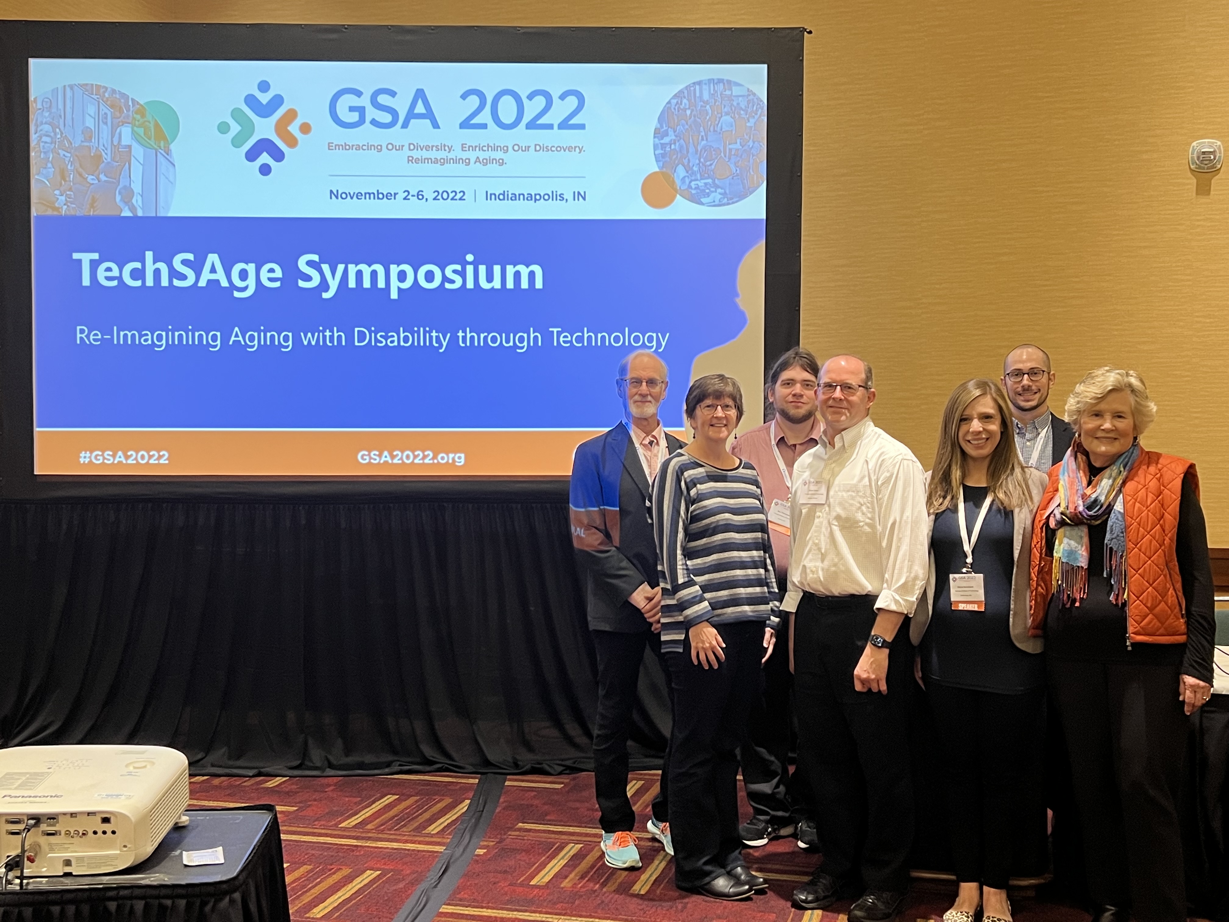 TechSAge team members in front of symposium screen at the 2022 Gerontological Society of America conference