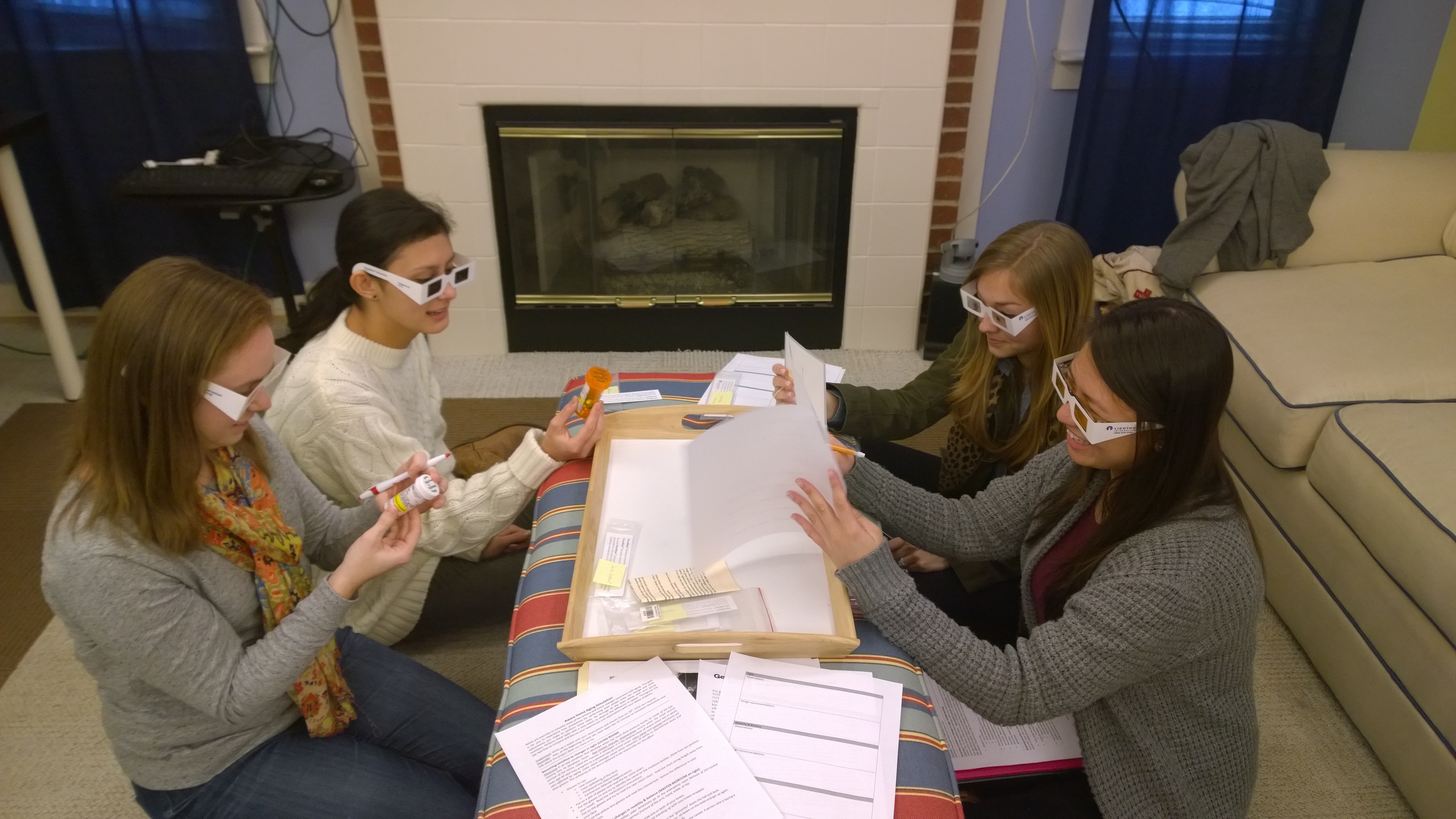 Four girls using special glasses to read prescription bottles