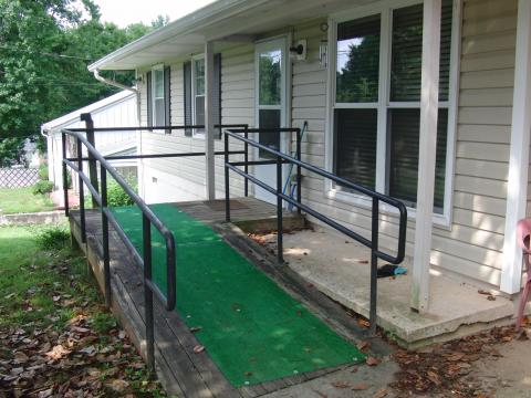 Wheelchair ramp leading to front door that is lined with astroturf