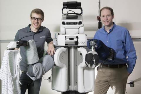 two men posing with life size robot